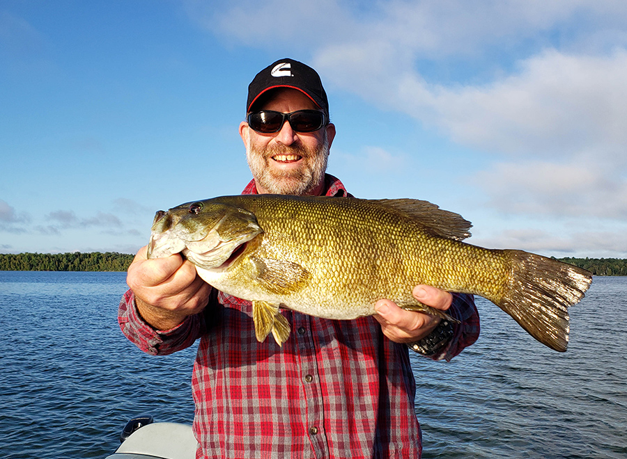 man on boat catches fish